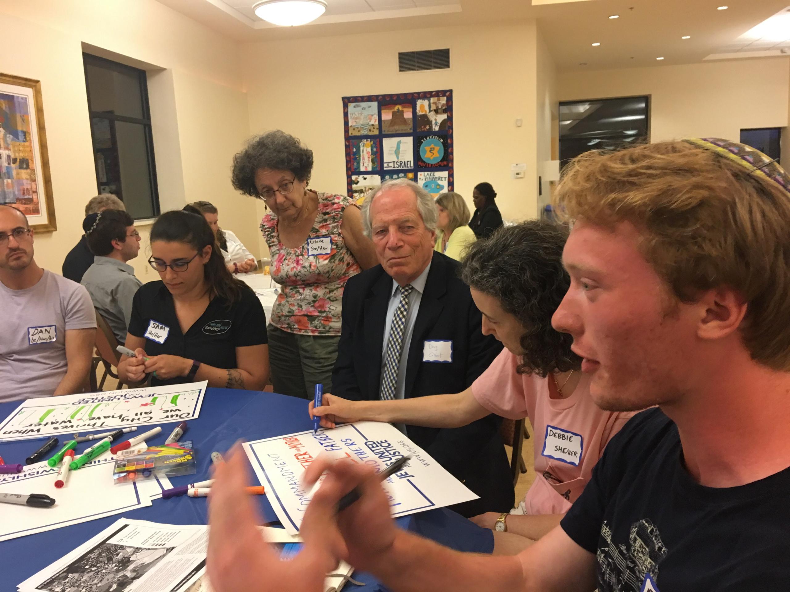 people sitting around a table making signs for a rally