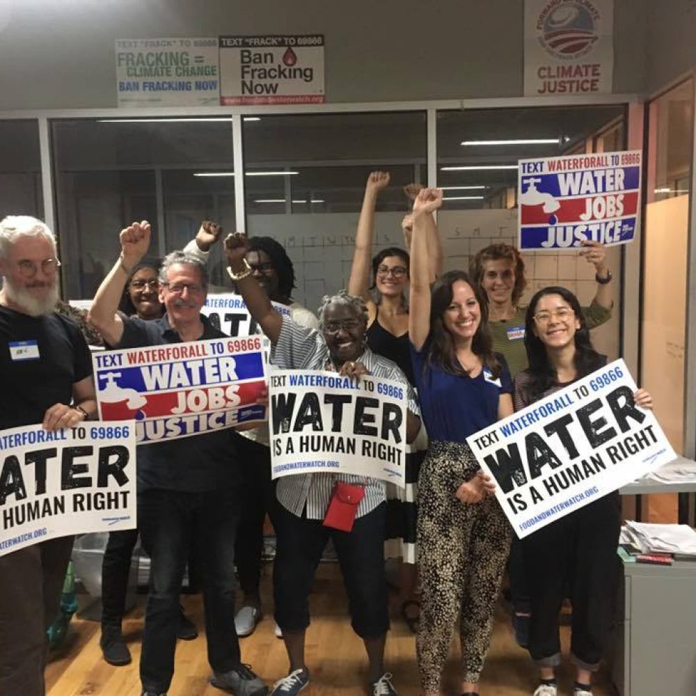 waterforall a group of people holding signs advocating that water is a human right