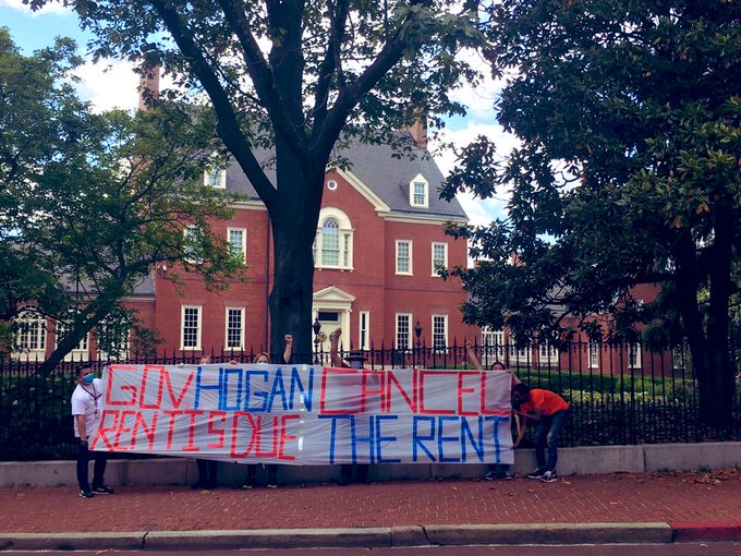 cancelrentbannercasa Two people hold a banner outside the Governor's mansion: Governor Hogan, Rent is Due. Cancel the Rent.