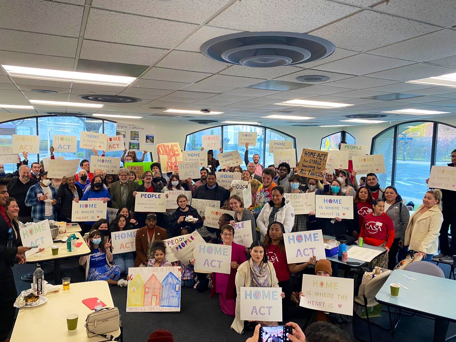Housing advocates hold signs for the HOME Act
